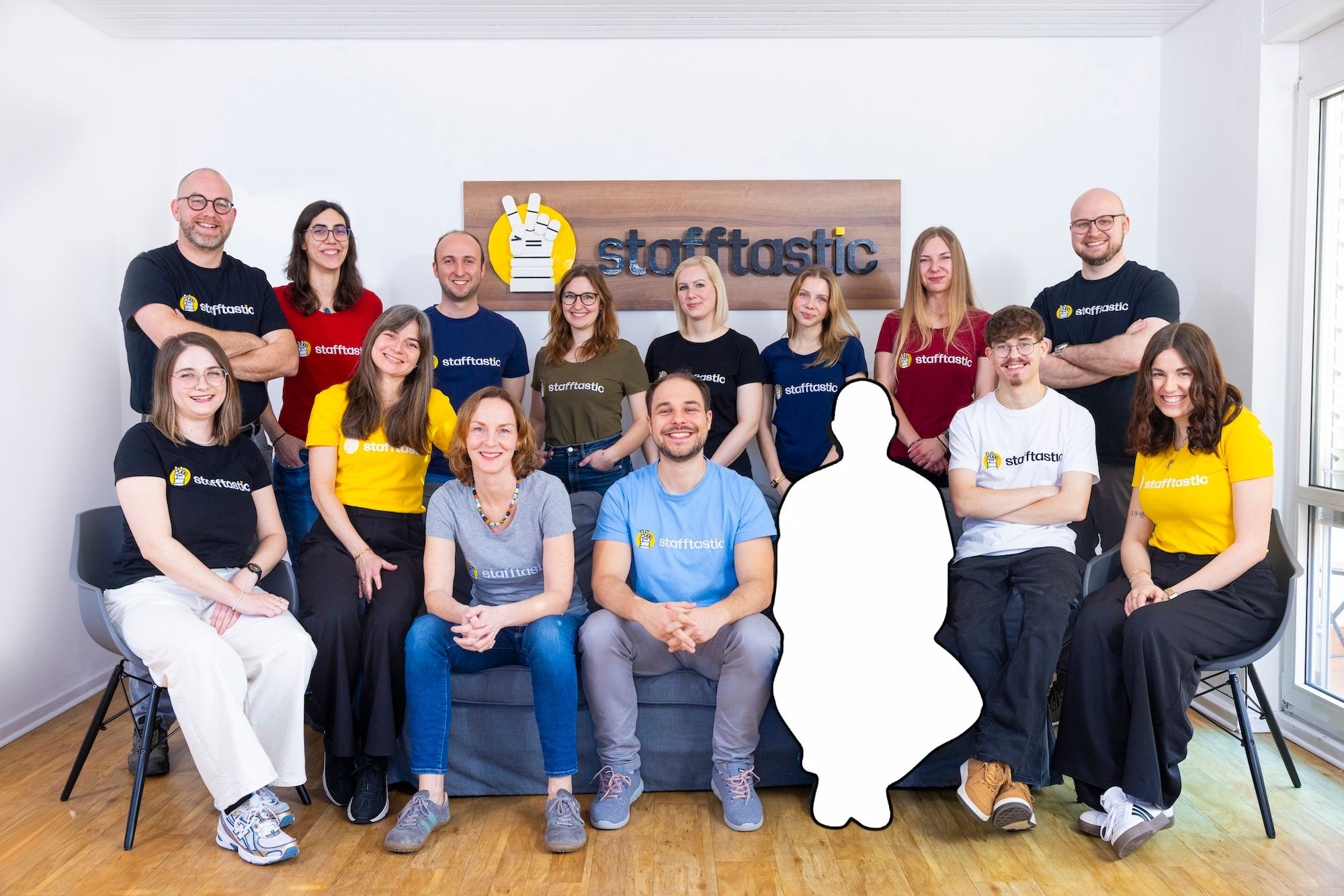 Stafftastic team gathered with a silhouette placeholder, symbolizing an open position.
